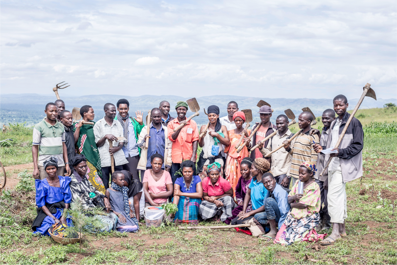 Vuxna deltagare i jordbruksskolan samlade på fältet i Uganda